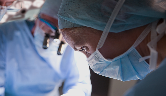 Female medical professional focusing on a surgical procedure