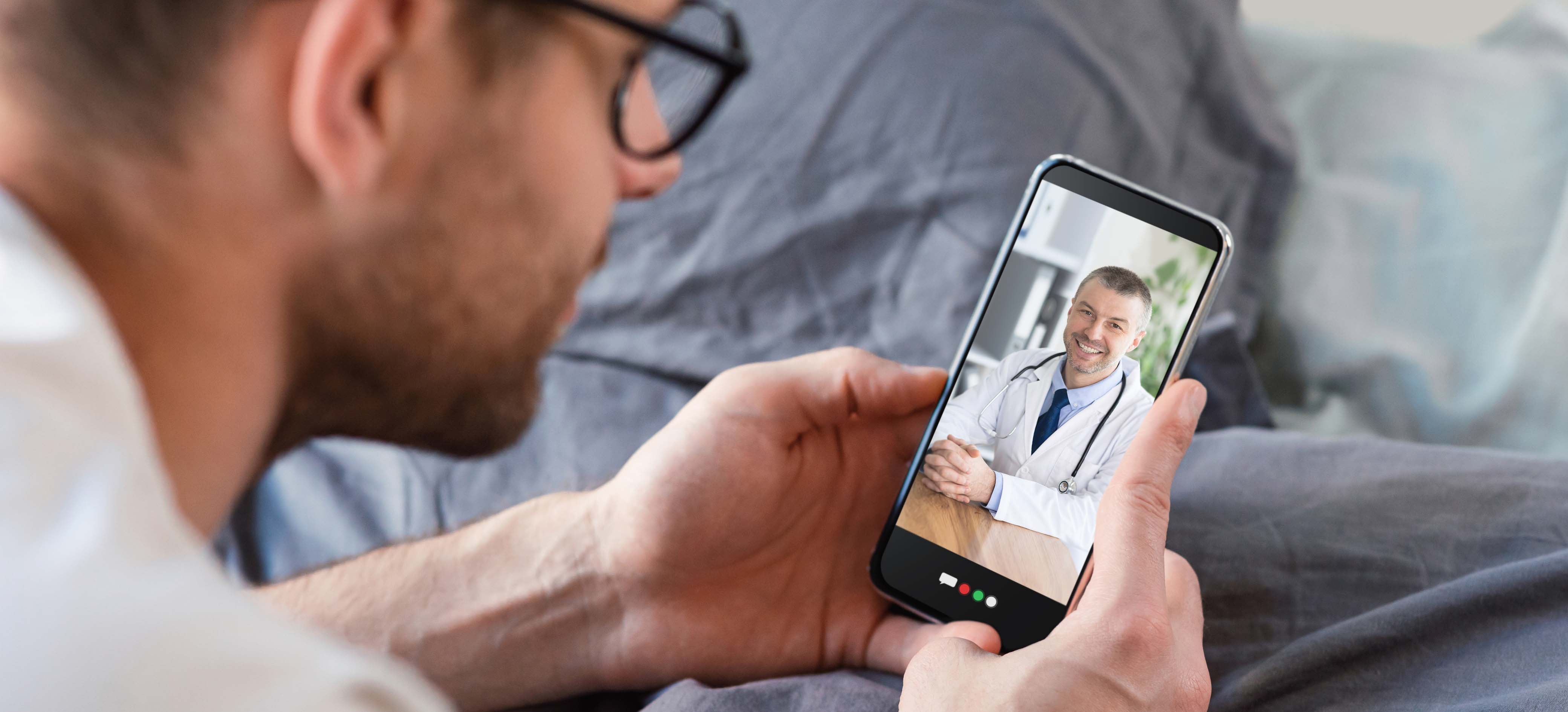 Man having a virtual visit with his doctor on a smartphone