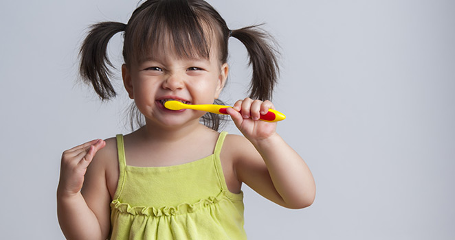 Toddler girl brushing her teeth