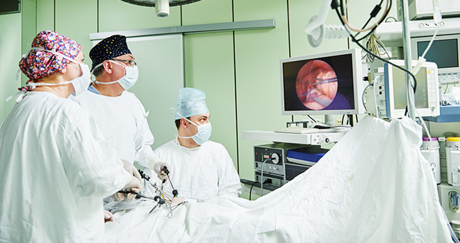 Surgeons watch monitor while performing an advanced procedure