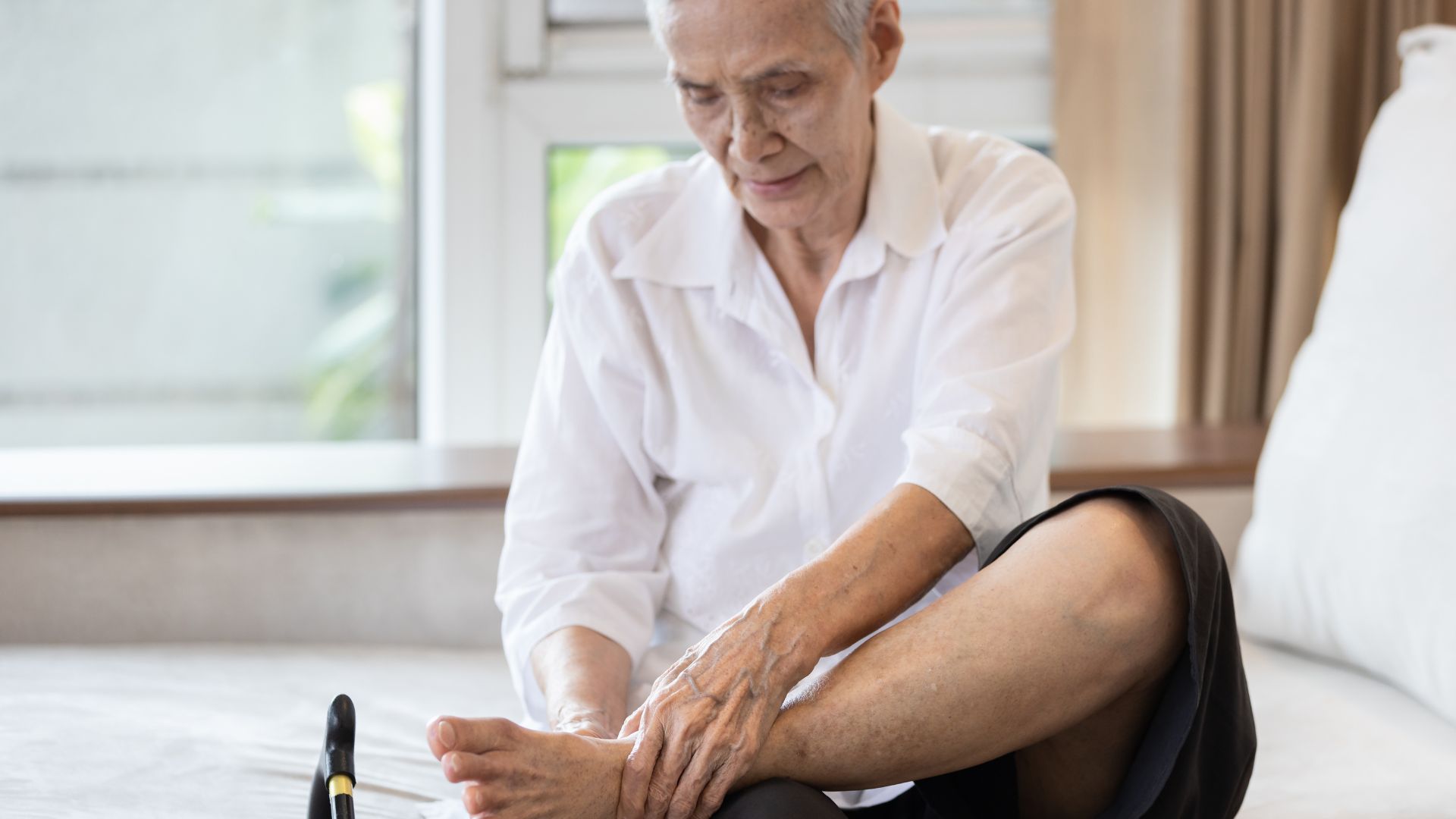 older person sitting and rubbing their feet