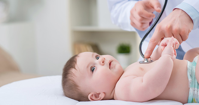 Infant laying on an exam table