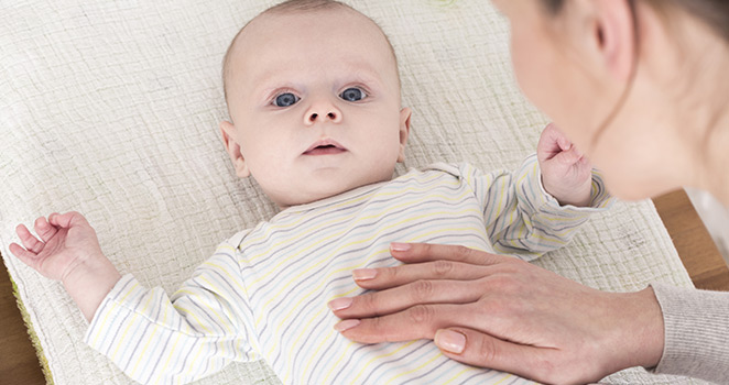 Infant getting an abdominal exam