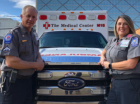 Atrium Health Navicent Emergency Medical Services, a Facility of Atrium Health Navicent The Medical Center Employees standing in front of ambulance