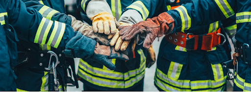 fire fighters putting their hands in for a huddle