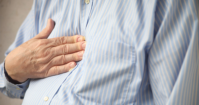 An older man holding his chest in pain