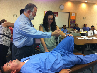 Resident learns from professor by examining a fellow resident