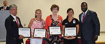 4 people holding awards at an awards ceremony