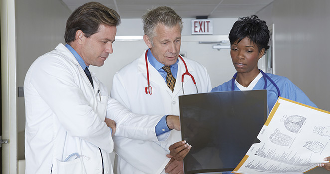 Doctors standing in a hospitalgoing over a patients scan results