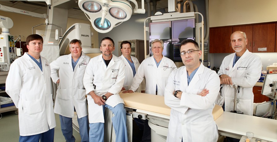 Group of doctors posing for a picture in an operating room