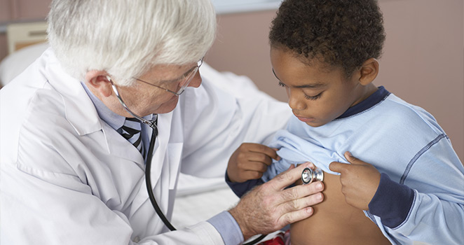 Doctor listens to a young boy's heart