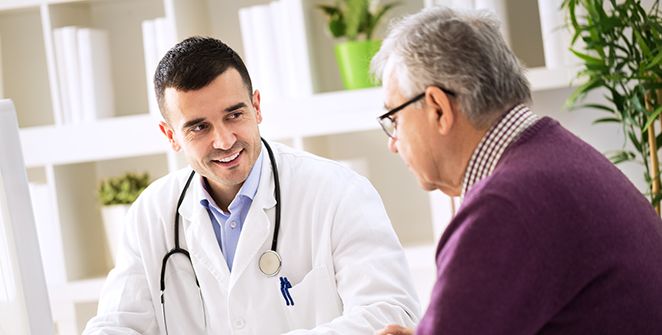 Doctor sitting with and speaking with a man