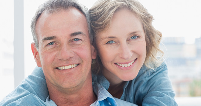 Woman with her arms around her husband smiling 