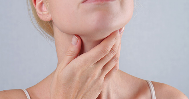 Young woman holding her neck in concern